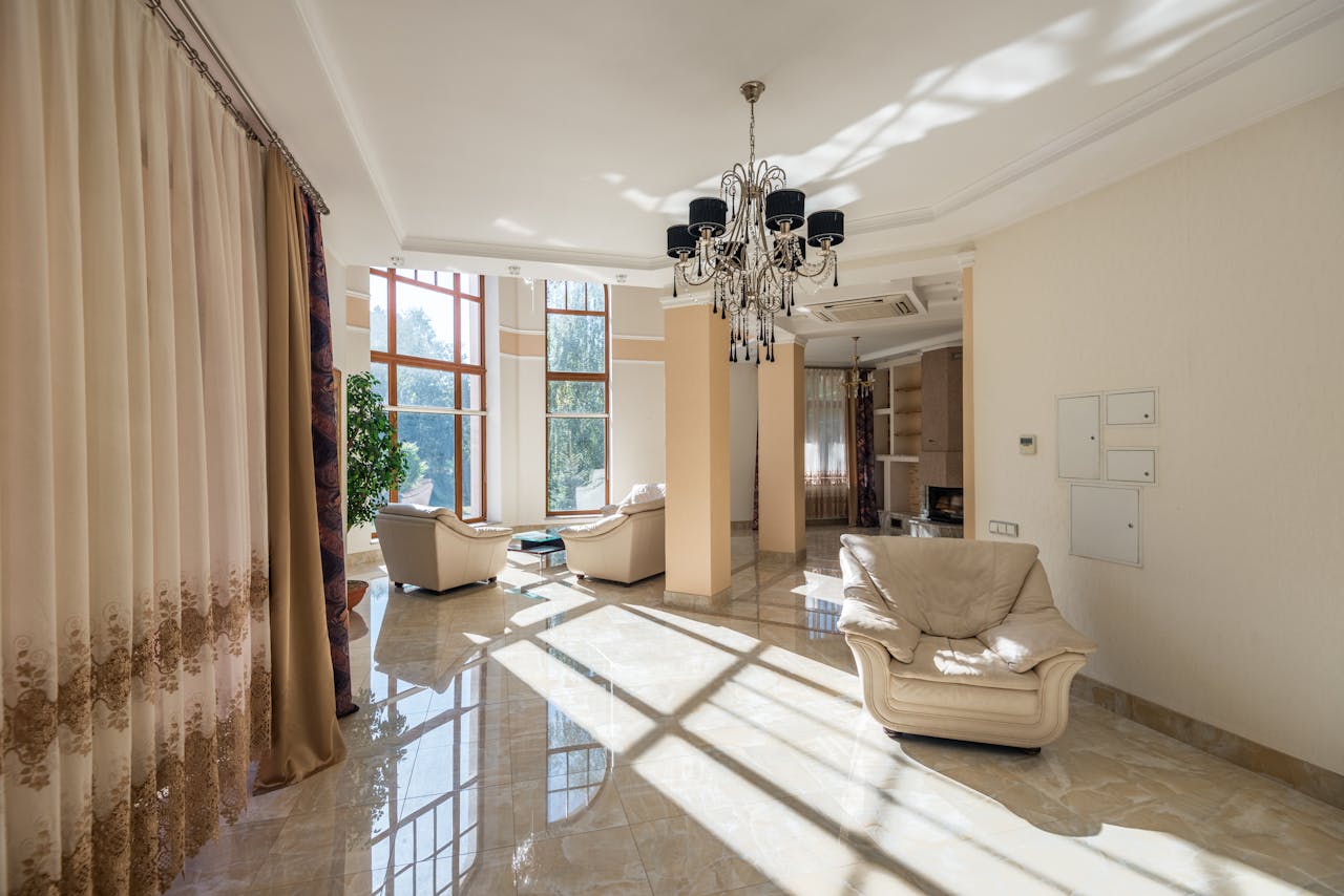 gallery-3 Luxurious living room featuring modern decor, large glass windows, and elegant chandelier.